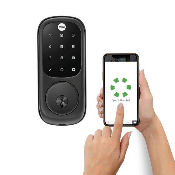 Yale Assure With Yale Access smart electronic lock featuring a sleek black touchscreen keypad. A user unlocks the door remotely via a smartphone app.